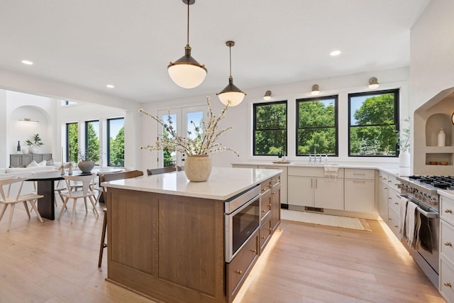 4404 58th St, Edina, MN 55424 - kitchen featuring stainless steel appliances, light wood-type flooring, light stone counters, a center island, and recessed lighting