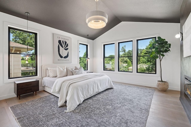 4404 58th St, Edina, MN 55424 - bedroom with vaulted ceiling, multiple windows, wood finished floors, and a textured ceiling