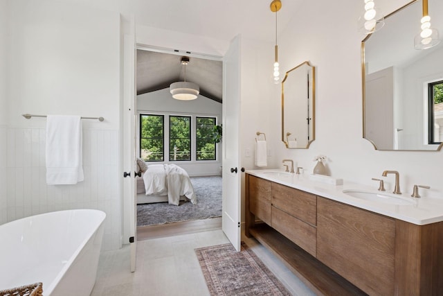 4404 58th St, Edina, MN 55424 - bathroom featuring a freestanding tub, lofted ceiling, double vanity, ensuite bath, and a wainscoted wall