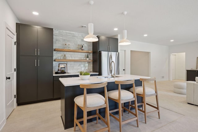 4404 58th St, Edina, MN 55424 - kitchen featuring freestanding refrigerator, an island with sink, light countertops, a kitchen breakfast bar, and recessed lighting