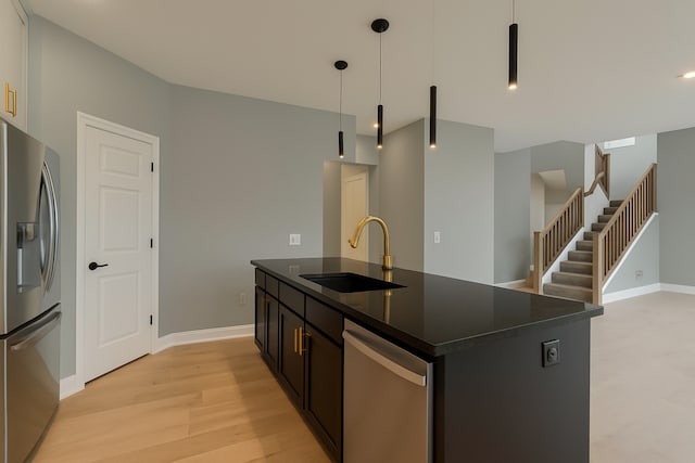 917 174th Ave NE, Ham Lake, MN 55304 - kitchen with stainless steel appliances, dark countertops, a center island with sink, open floor plan, and light wood-type flooring