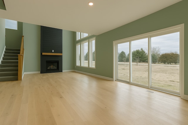 917 174th Ave NE, Ham Lake, MN 55304 - unfurnished living room with light wood-style flooring, a large fireplace, stairs, and recessed lighting