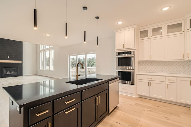917 174th Ave NE, Ham Lake, MN 55304 - kitchen with stainless steel appliances, white cabinets, tasteful backsplash, hanging light fixtures, and light wood-type flooring