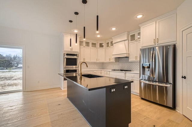 917 174th Ave NE, Ham Lake, MN 55304 - kitchen featuring appliances with stainless steel finishes, premium range hood, light wood-style flooring, backsplash, and white cabinetry