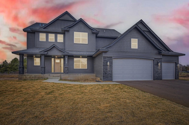 917 174th Ave NE, Ham Lake, MN 55304 - craftsman-style home with asphalt driveway, a front yard, stone siding, and a garage