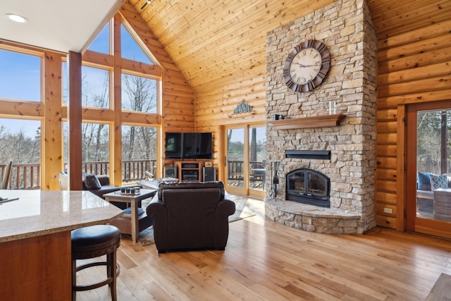 15193 Wilderness Trl, Crosslake, MN 56442 - living room featuring high vaulted ceiling, light wood-type flooring, a stone fireplace, wood ceiling, and log walls