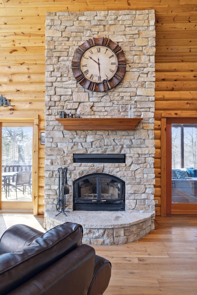 15193 Wilderness Trl, Crosslake, MN 56442 - living room featuring rustic walls, wood-type flooring, and a stone fireplace