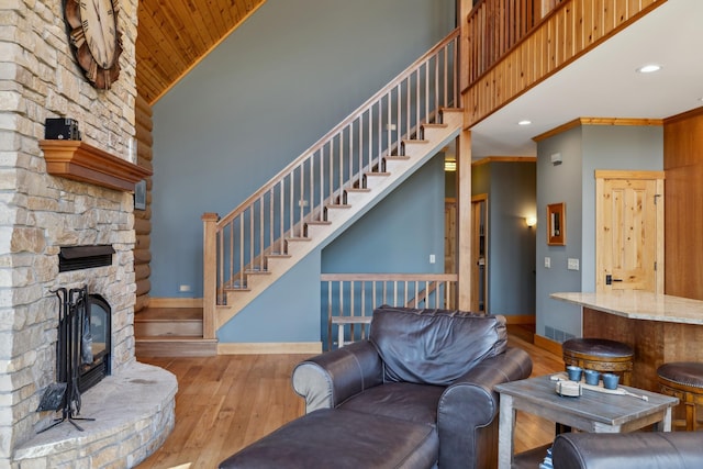15193 Wilderness Trl, Crosslake, MN 56442 - living room with a fireplace, hardwood / wood-style floors, high vaulted ceiling, stairs, and wood ceiling