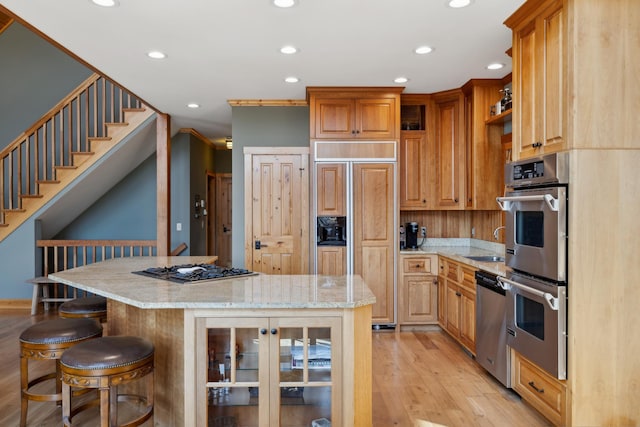 15193 Wilderness Trl, Crosslake, MN 56442 - kitchen with stainless steel appliances, light wood-style floors, recessed lighting, a kitchen breakfast bar, and glass insert cabinets