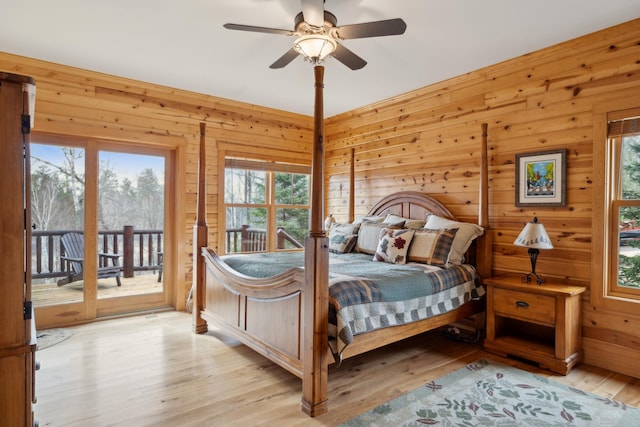 15193 Wilderness Trl, Crosslake, MN 56442 - bedroom with access to outside, wood finished floors, wooden walls, and multiple windows