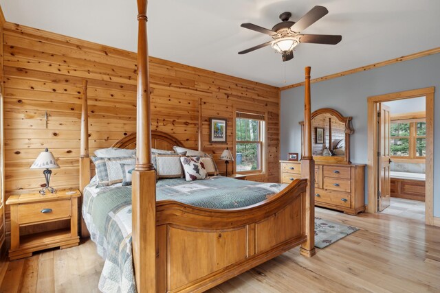 15193 Wilderness Trl, Crosslake, MN 56442 - bedroom with light wood-type flooring, ensuite bath, wooden walls, and ceiling fan