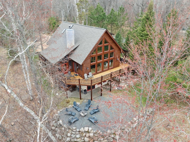 15193 Wilderness Trl, Crosslake, MN 56442 - back of property with a deck, a chimney, and a forest view