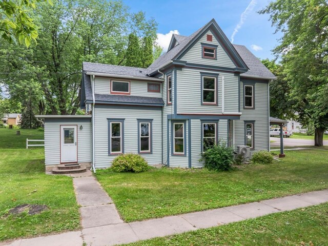 202 Cedar St, Pepin, WI 54759 - victorian house with a front yard and roof with shingles