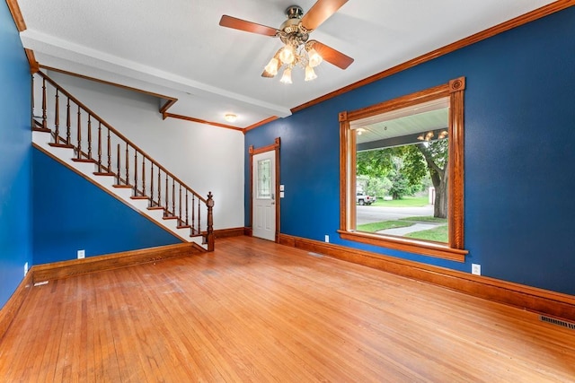 202 Cedar St, Pepin, WI 54759 - foyer entrance with wood finished floors, stairs, ceiling fan, and crown molding