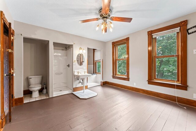 202 Cedar St, Pepin, WI 54759 - bathroom featuring hardwood / wood-style flooring, a stall shower, and a ceiling fan