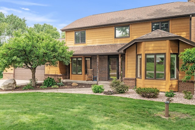 9950 204th Street Ct N, Forest Lake, MN 55025 - view of front facade with a porch, a front lawn, brick siding, a shingled roof, and an attached garage