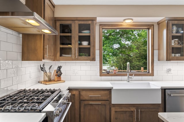 9950 204th Street Ct N, Forest Lake, MN 55025 - kitchen featuring wall chimney exhaust hood, stainless steel range with gas cooktop, glass insert cabinets, and decorative backsplash