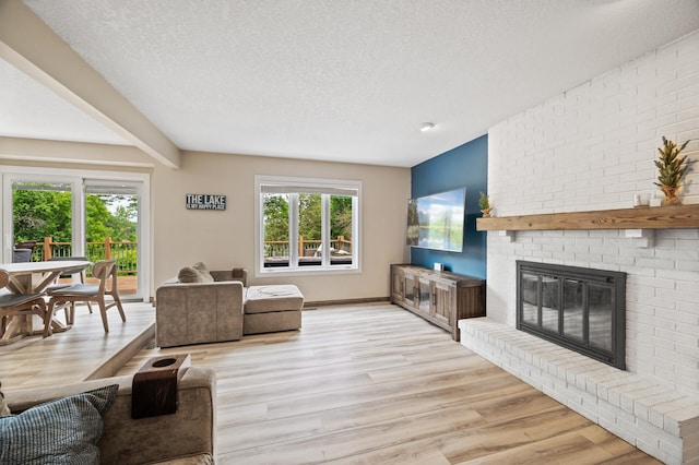 9950 204th Street Ct N, Forest Lake, MN 55025 - living area featuring a textured ceiling, a brick fireplace, and light wood-type flooring