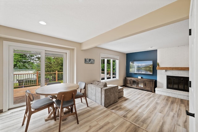 9950 204th Street Ct N, Forest Lake, MN 55025 - dining space featuring light wood-type flooring, a fireplace, recessed lighting, and beam ceiling