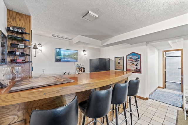 9950 204th Street Ct N, Forest Lake, MN 55025 - indoor bar with freestanding refrigerator, a textured ceiling, and light tile patterned flooring