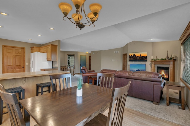 1664 Payton Ct NE, Sauk Rapids, MN 56379 - dining space featuring light wood-style floors, a glass covered fireplace, recessed lighting, lofted ceiling, and a chandelier