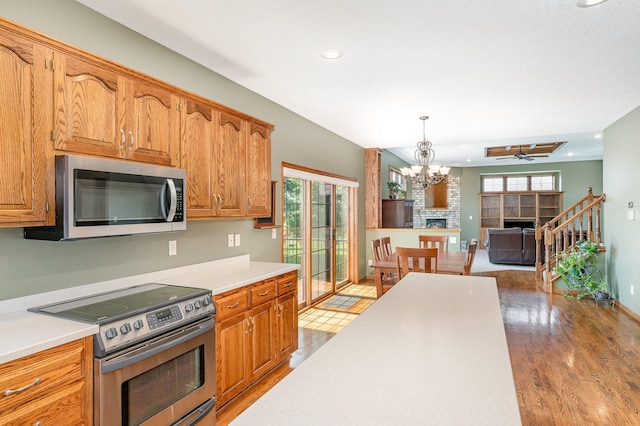 517 Redpoll Ave SE, New Prague, MN 56071 - kitchen with stainless steel appliances, wood finished floors, light countertops, recessed lighting, and a fireplace