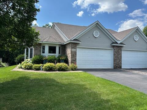 12440 Eagle Cir NW, Coon Rapids, MN 55448 - ranch-style house featuring an attached garage, a front yard, and brick siding