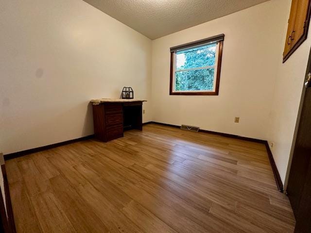 2671 4th Ave NE, Rochester, MN 55906 - unfurnished room featuring wood finished floors and a textured ceiling