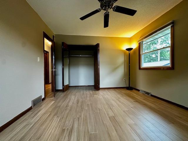2671 4th Ave NE, Rochester, MN 55906 - unfurnished bedroom with light wood-type flooring, a closet, and ceiling fan