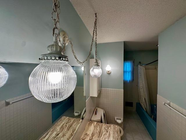 2671 4th Ave NE, Rochester, MN 55906 - detailed view of a wainscoted wall, a textured ceiling, and tile walls