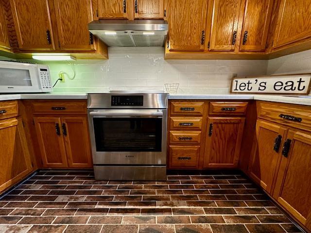 2671 4th Ave NE, Rochester, MN 55906 - kitchen with stainless steel range with electric cooktop, range hood, white microwave, and light countertops