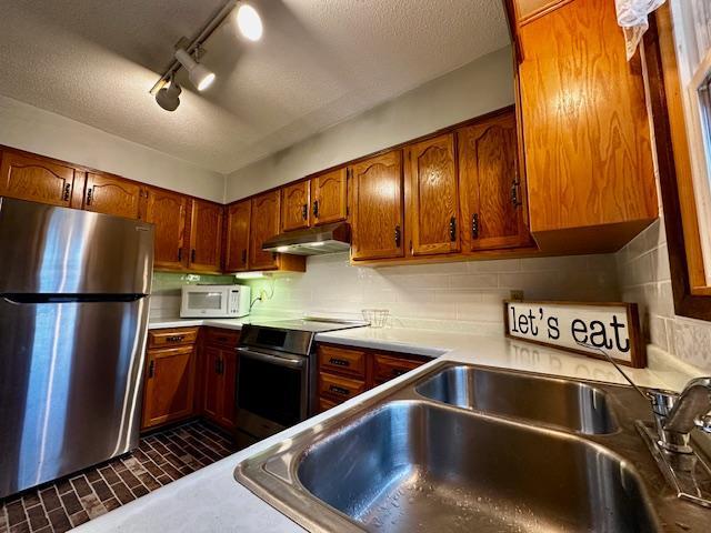 2671 4th Ave NE, Rochester, MN 55906 - kitchen featuring stainless steel appliances, under cabinet range hood, brown cabinets, light countertops, and decorative backsplash