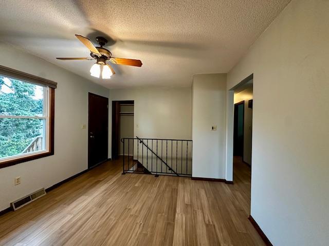 2671 4th Ave NE, Rochester, MN 55906 - spare room with wood finished floors, ceiling fan, and a textured ceiling