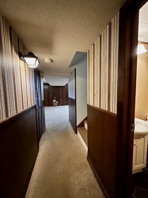 2671 4th Ave NE, Rochester, MN 55906 - hallway with wallpapered walls, a textured ceiling, carpet flooring, and stairway