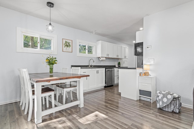 706 2nd Ave NW, New Brighton, MN 55112 - kitchen with white cabinets, dark countertops, wood finished floors, dishwasher, and recessed lighting