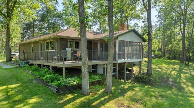 11100 Fisher Ln, Park Rapids, MN 56470 - rear view of house with a sunroom, a chimney, a yard, and a wooden deck