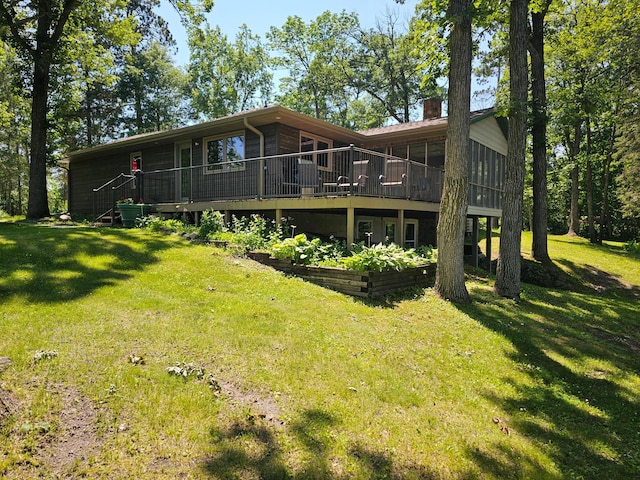 11100 Fisher Ln, Park Rapids, MN 56470 - back of house featuring a chimney, a lawn, and a wooden deck
