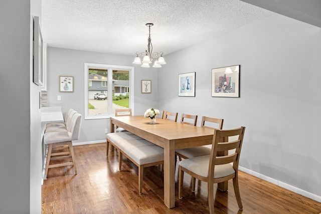 6721 Limerick Ln, Edina, MN 55439 - dining room featuring a chandelier, wood finished floors, and a textured ceiling