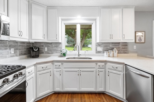6721 Limerick Ln, Edina, MN 55439 - kitchen featuring appliances with stainless steel finishes, white cabinets, tasteful backsplash, dark wood finished floors, and light stone countertops
