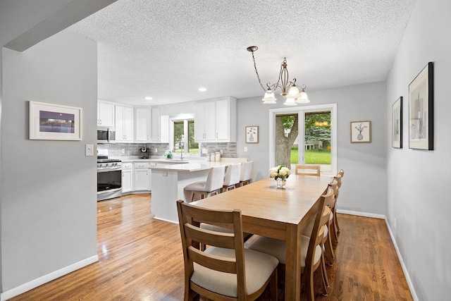 6721 Limerick Ln, Edina, MN 55439 - dining space with a textured ceiling, light wood-type flooring, a chandelier, and recessed lighting