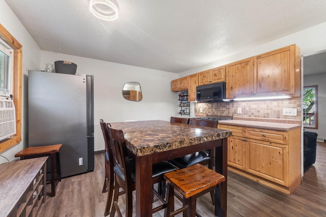 311 70th Ave W, Duluth, MN 55807 - kitchen featuring freestanding refrigerator, black microwave, dark wood-style flooring, decorative backsplash, and a textured ceiling