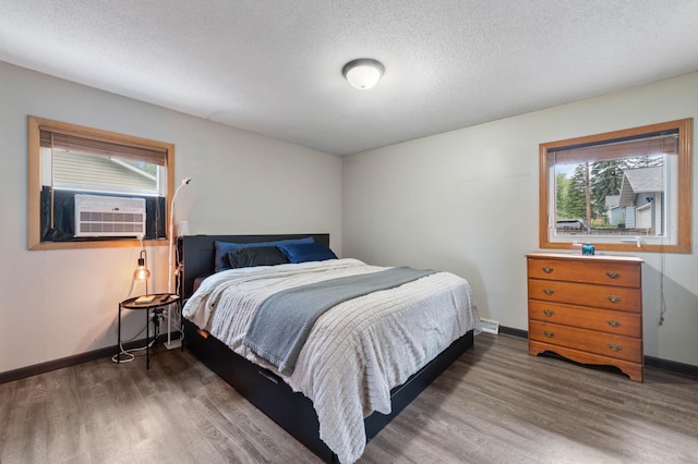 311 70th Ave W, Duluth, MN 55807 - bedroom featuring wood finished floors, cooling unit, and a textured ceiling
