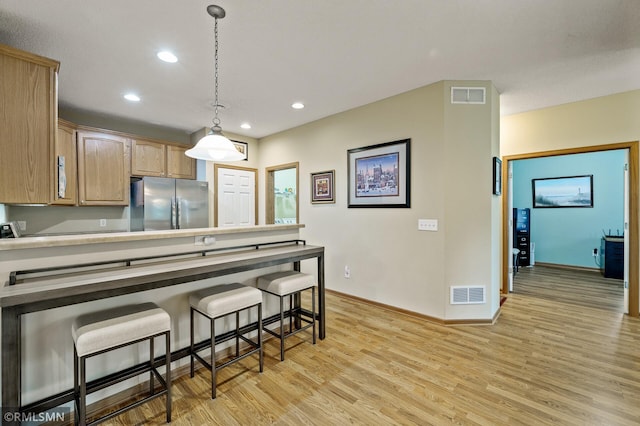 20177 Farnham Ln N, Forest Lake, MN 55025 - kitchen with freestanding refrigerator, light wood-style floors, recessed lighting, a kitchen breakfast bar, and hanging light fixtures