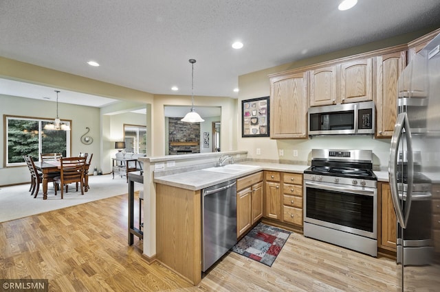 20177 Farnham Ln N, Forest Lake, MN 55025 - kitchen featuring appliances with stainless steel finishes, a peninsula, recessed lighting, light wood-style flooring, and light countertops