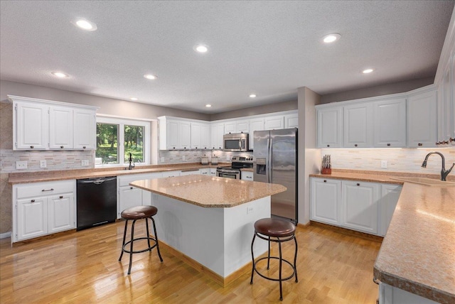 N6386 1317th St, Clifton Twp, WI 54021 - kitchen featuring stainless steel appliances, a breakfast bar, tasteful backsplash, white cabinetry, and recessed lighting