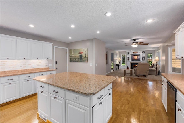 N6386 1317th St, Clifton Twp, WI 54021 - kitchen with dishwasher, a ceiling fan, decorative backsplash, a textured ceiling, and a kitchen island
