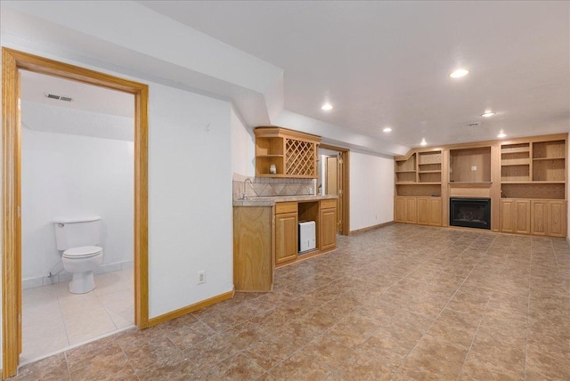 N6386 1317th St, Clifton Twp, WI 54021 - unfurnished living room featuring recessed lighting, a fireplace, bar area, light tile patterned flooring, and built in features