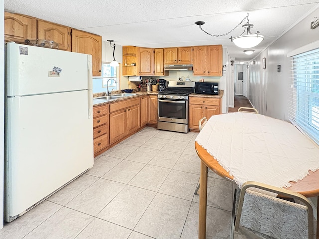 2890 216th St, Laketown Twp, WI 54853 - kitchen featuring freestanding refrigerator, gas range, black microwave, under cabinet range hood, and plenty of natural light