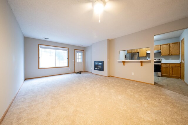 4316 Meghan Ln Unit 402, Eagan, MN 55122 - unfurnished living room featuring light carpet, a glass covered fireplace, and ceiling fan