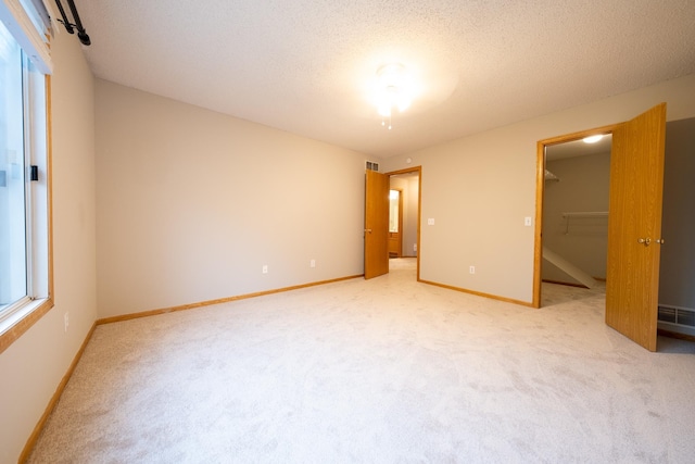 4316 Meghan Ln Unit 402, Eagan, MN 55122 - unfurnished bedroom with light carpet, a spacious closet, and a textured ceiling